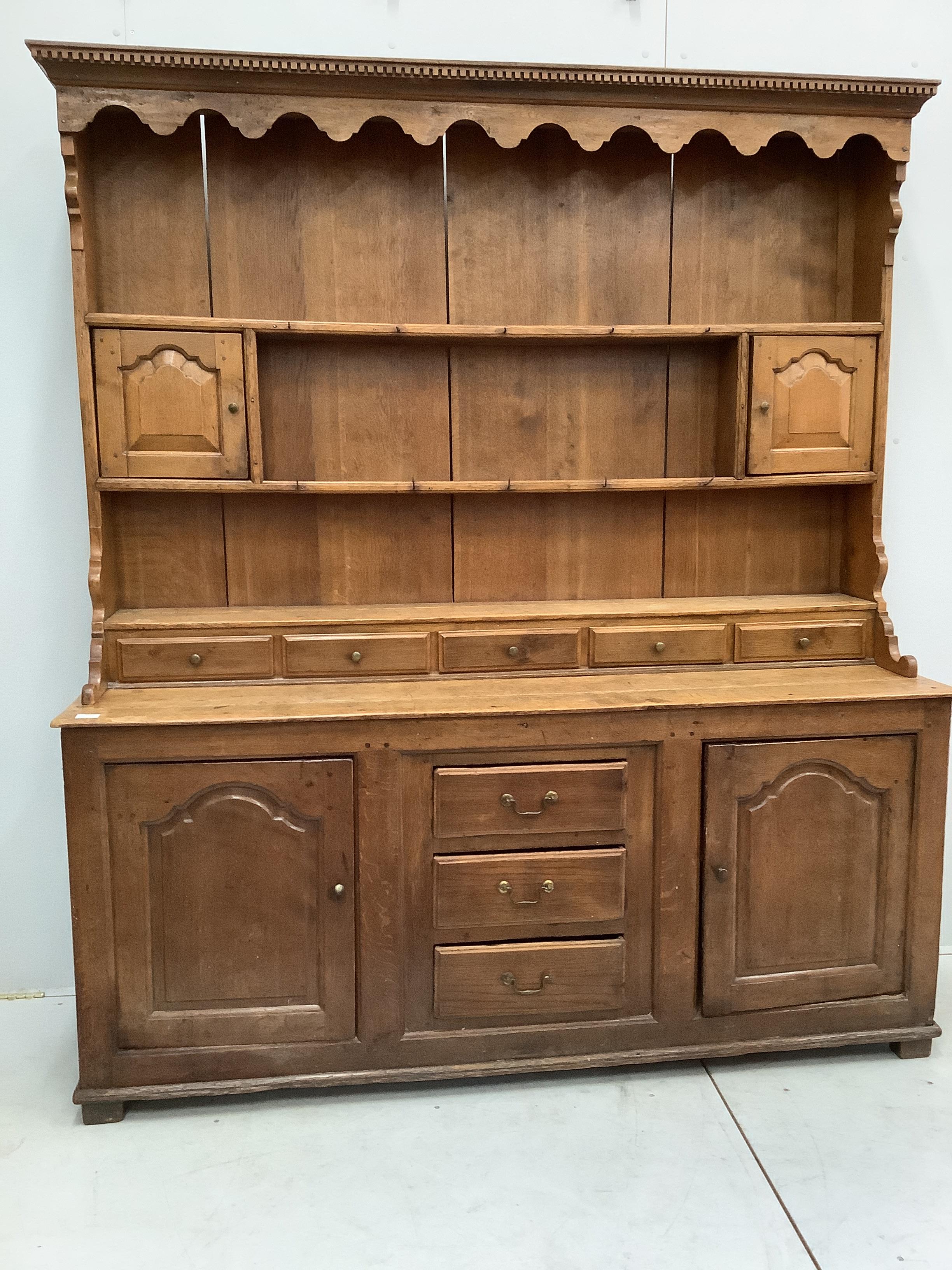 An 18th century oak dresser with boarded rack width 181cm, depth 51cm, height 207cm